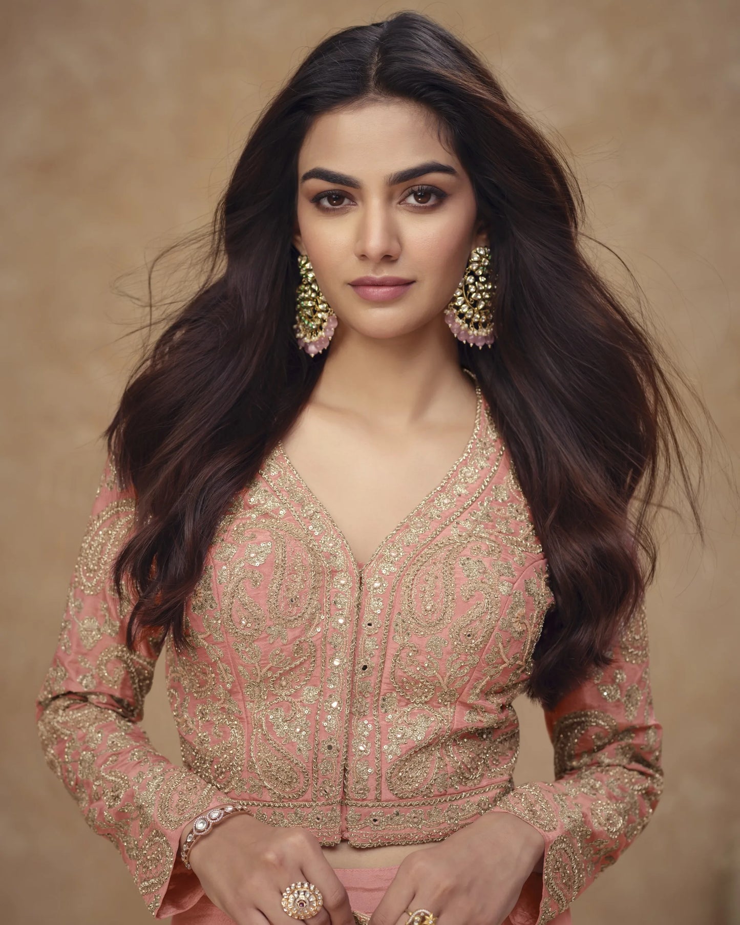 Woman wearing a traditional outfit with intricate designs on a beige background