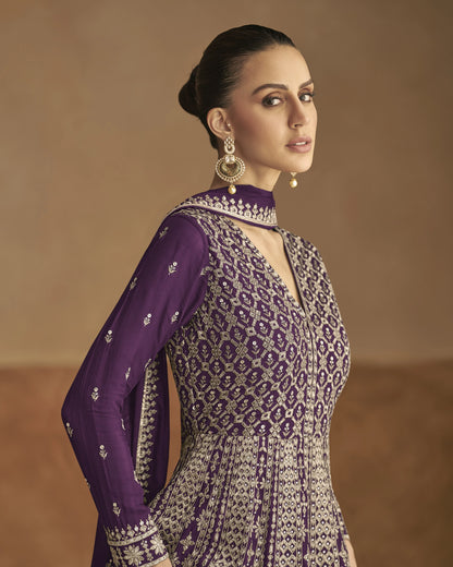 Woman wearing a purple and white patterned outfit against a brown background