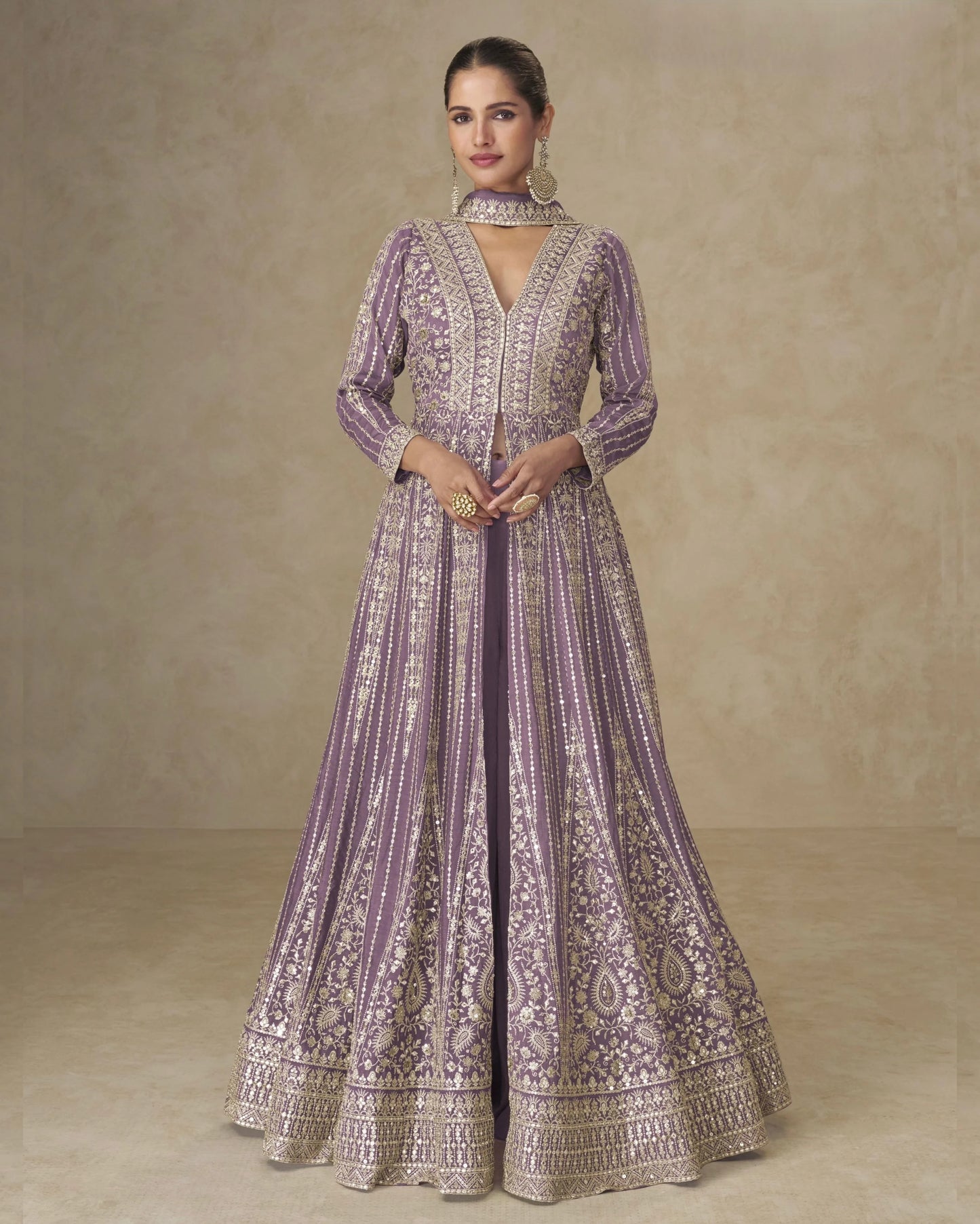 Woman wearing a purple and gold embroidered dress against a beige background