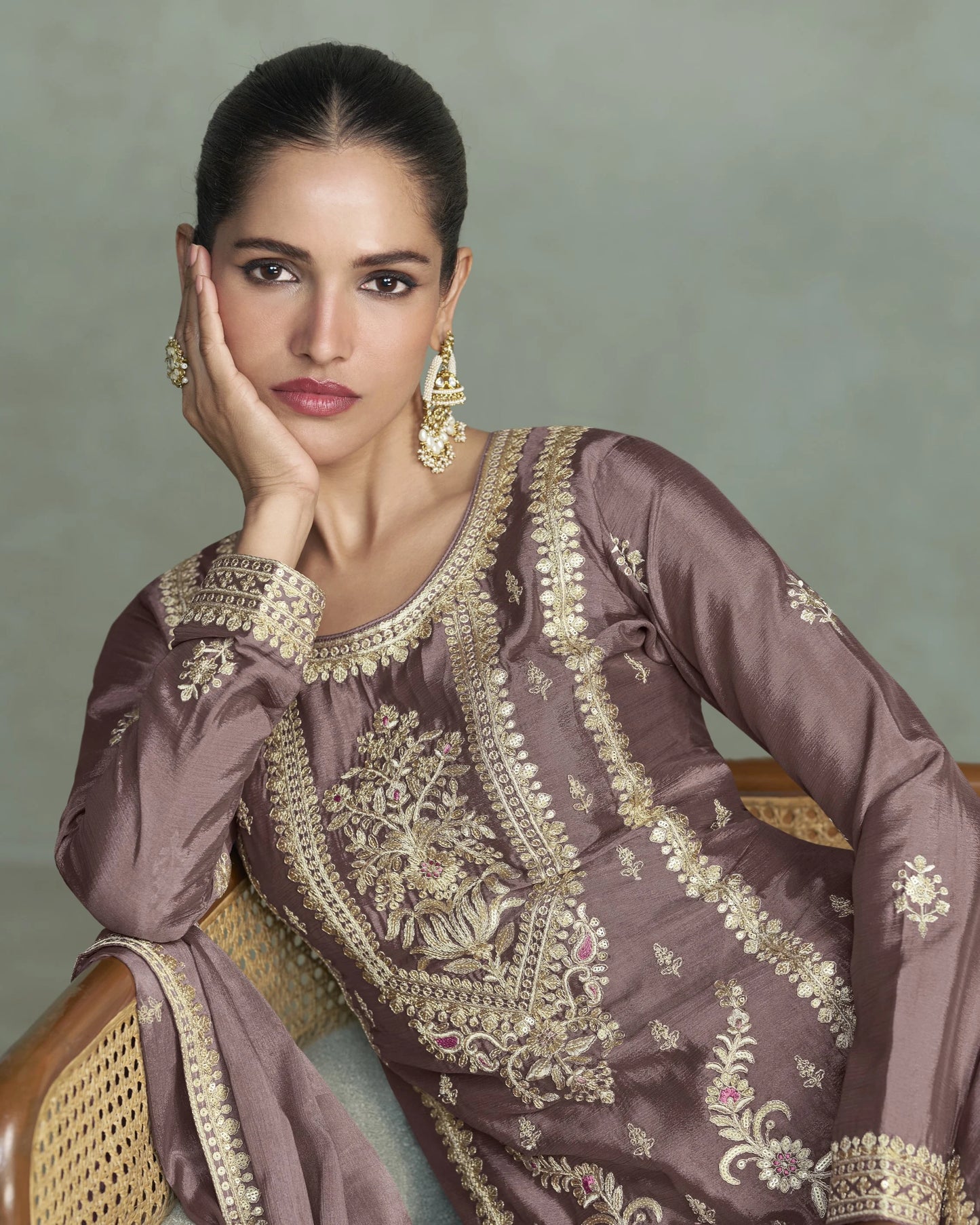 Woman wearing an embroidered traditional outfit with a neutral background