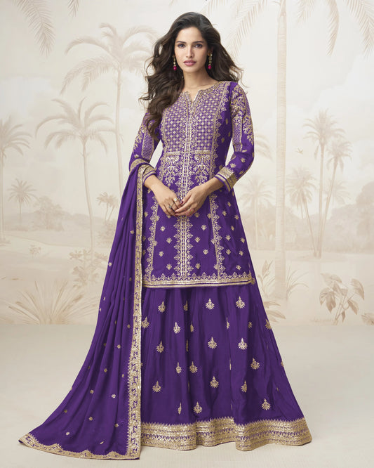 Woman wearing a purple embroidered traditional outfit with a matching dupatta against a neutral background