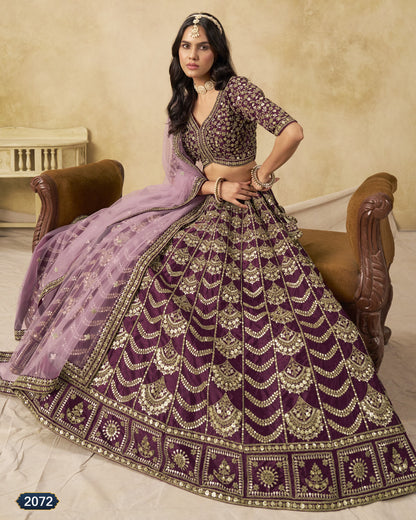 Woman in a traditional purple and gold embroidered outfit sitting on a wooden chair.