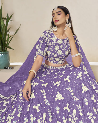 Woman wearing a purple floral traditional outfit with a plant in the background