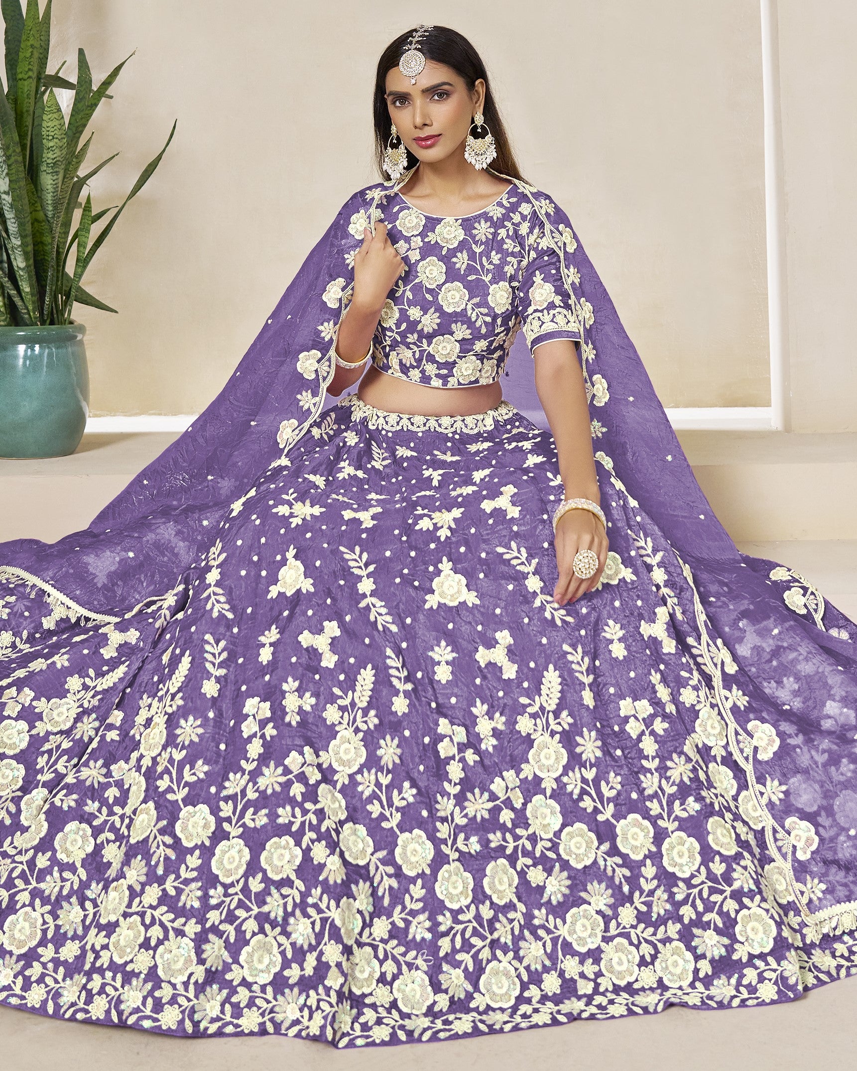 Woman wearing a purple floral lehenga with a matching blouse.