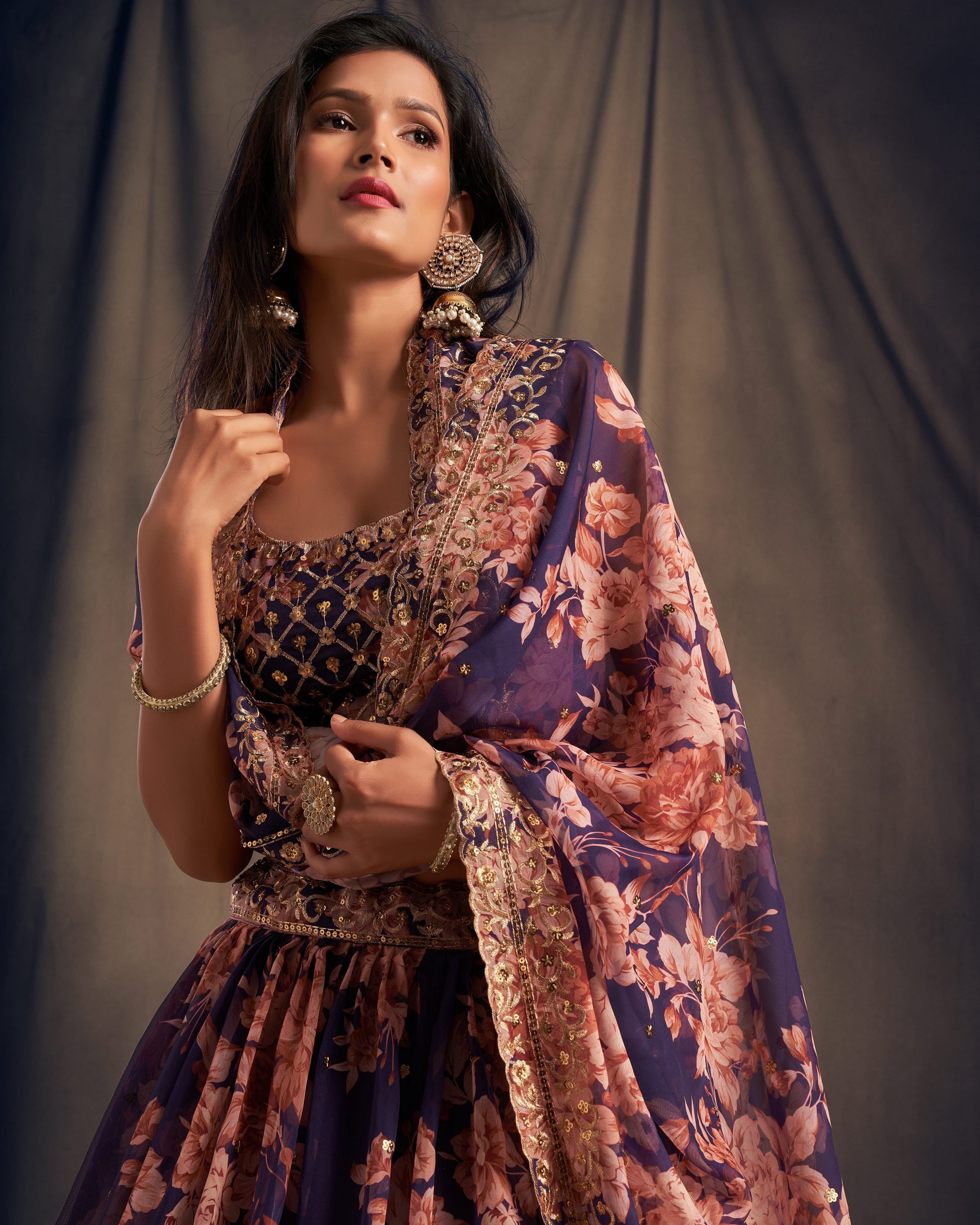Woman wearing a floral traditional outfit against a plain background