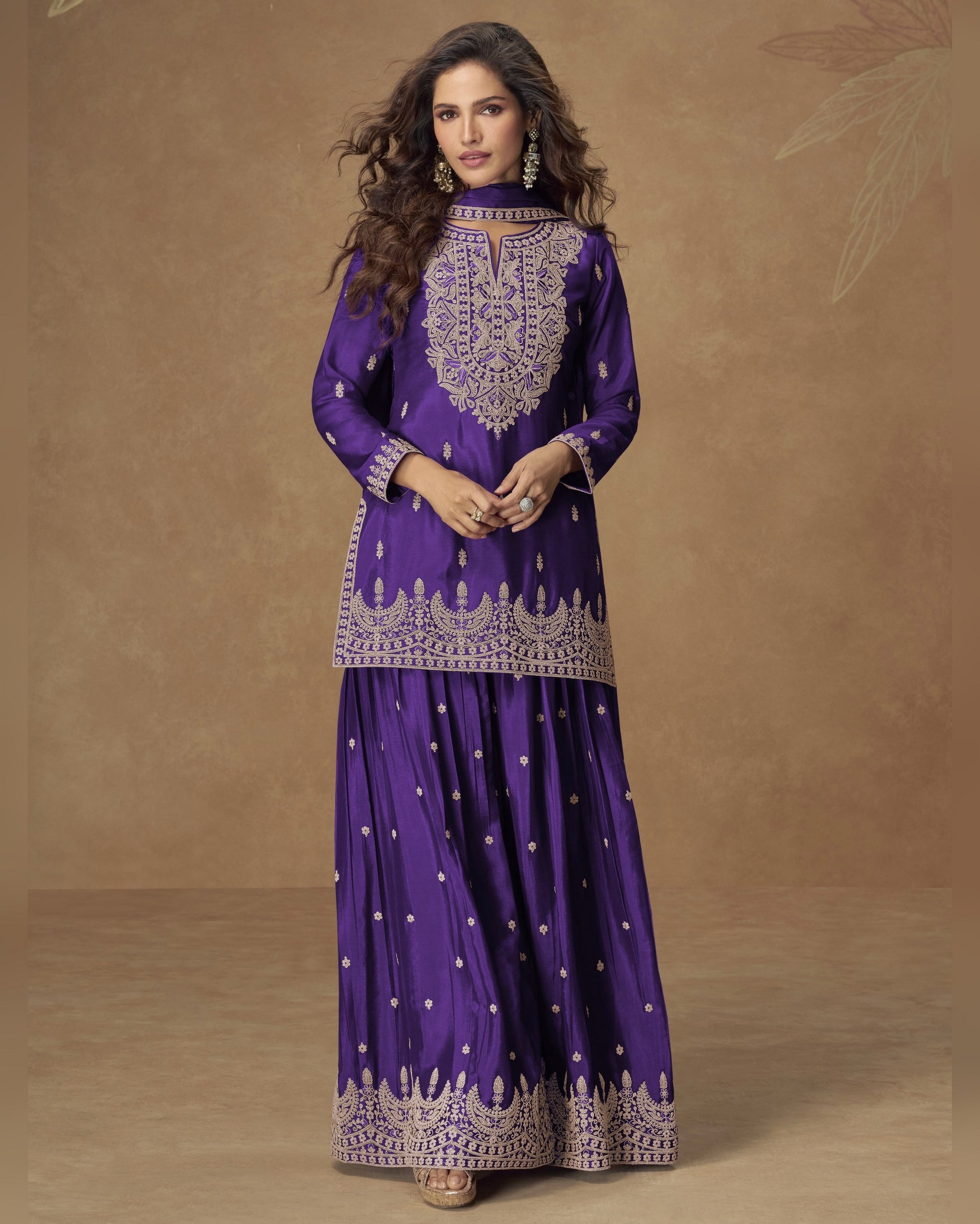 Woman wearing a purple traditional outfit with intricate designs on a brown background
