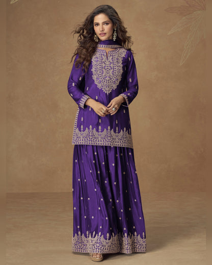 Woman wearing a purple traditional outfit with intricate designs on a brown background
