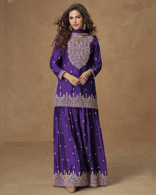 Woman wearing a purple traditional outfit with intricate designs on a brown background