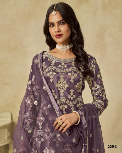 Woman wearing a purple embroidered traditional outfit with a beige background
