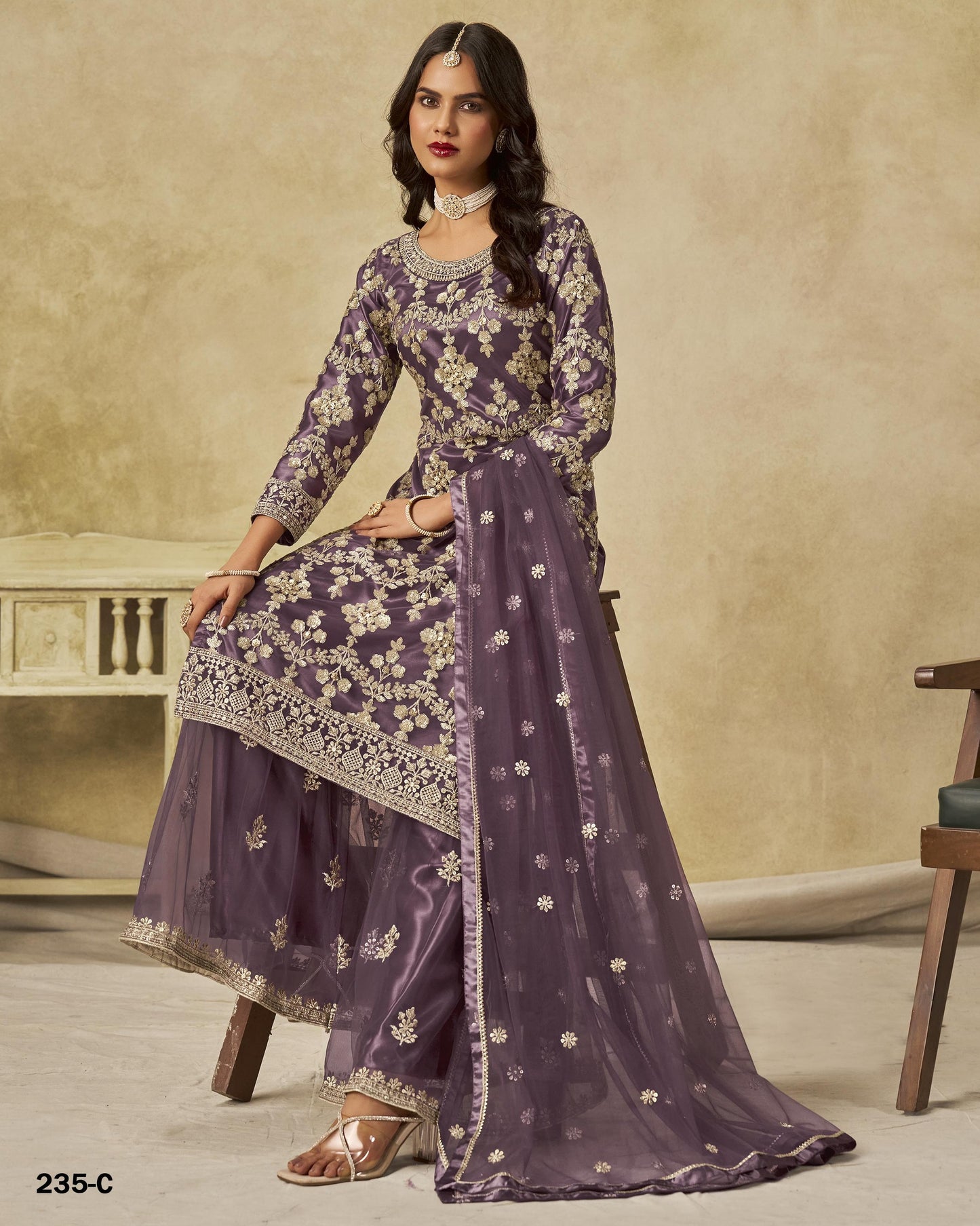 Woman wearing a purple traditional outfit with floral patterns on a beige background