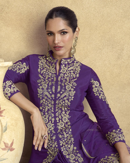 Woman wearing a purple embroidered outfit against a beige background