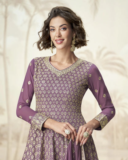 Woman wearing a purple patterned dress with a plain background