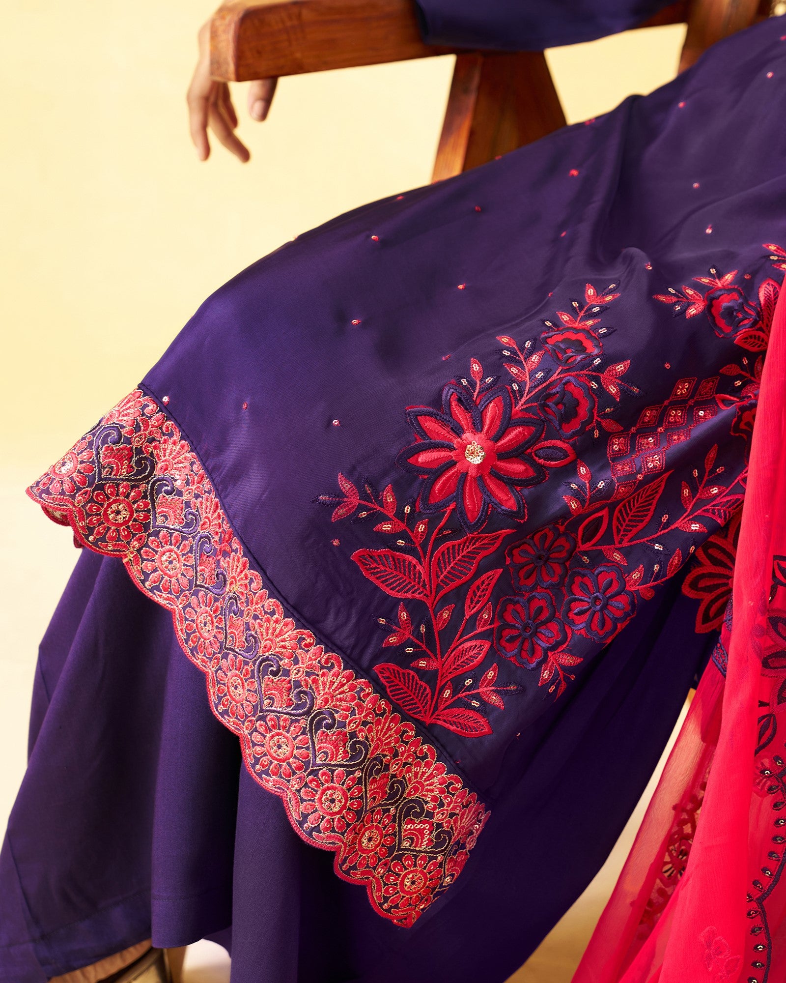 Navy blue fabric with red floral embroidery on a chair.