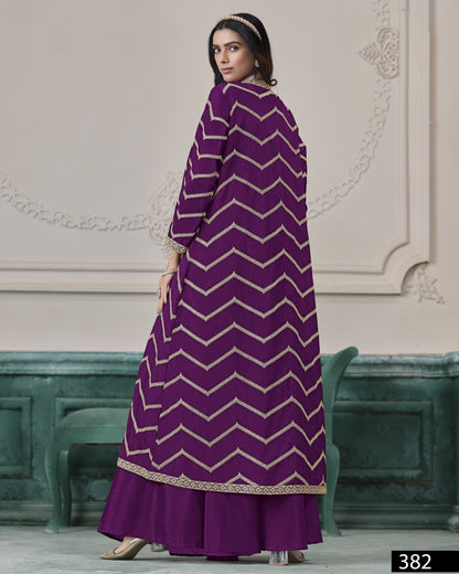 Woman wearing a purple dress with white zigzag pattern in an elegant interior setting.