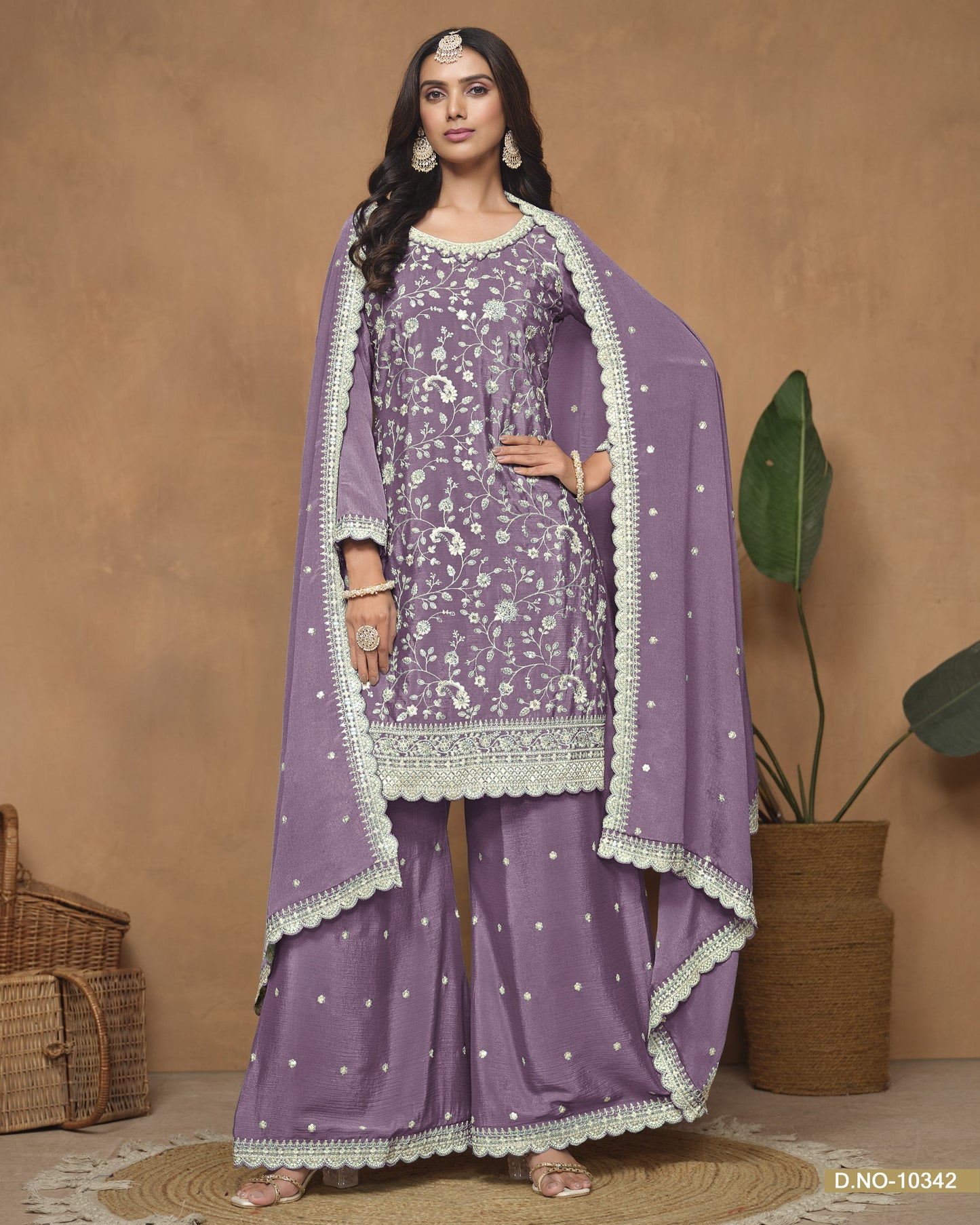 Woman wearing a purple traditional outfit with a matching dupatta against a beige background