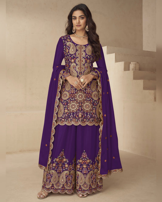 Woman wearing a purple embroidered traditional outfit in a neutral setting