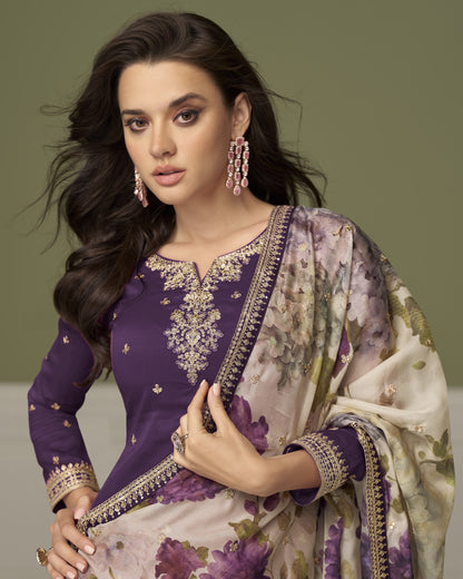 Woman wearing a traditional outfit with purple and floral patterns on a plain background