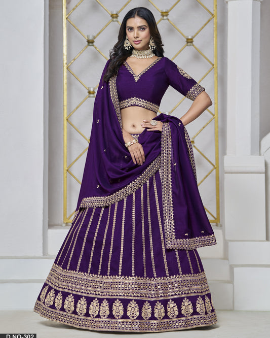 Woman wearing a purple embroidered traditional outfit with gold details against a decorative wall.