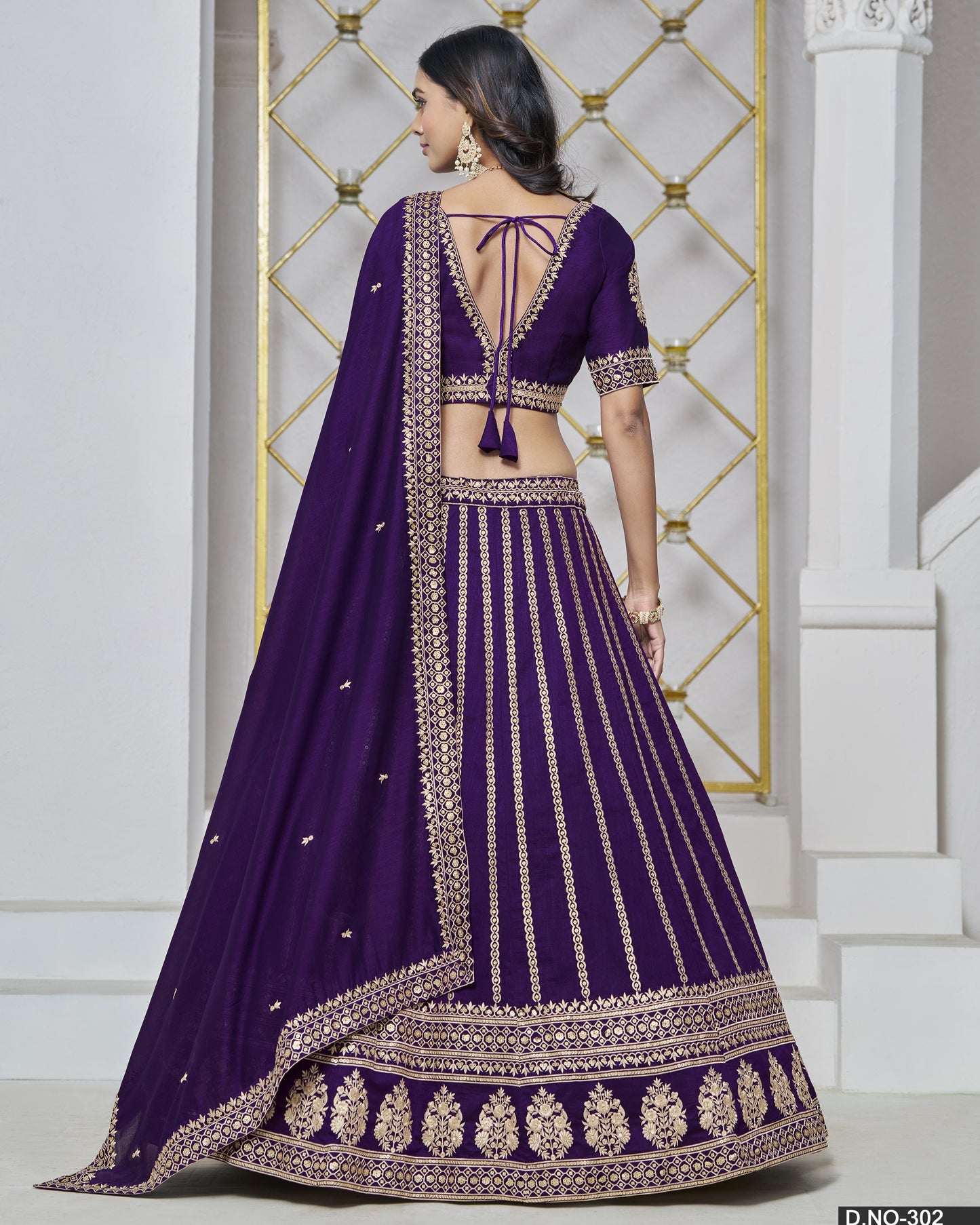 Purple embroidered lehenga with gold details on a white background