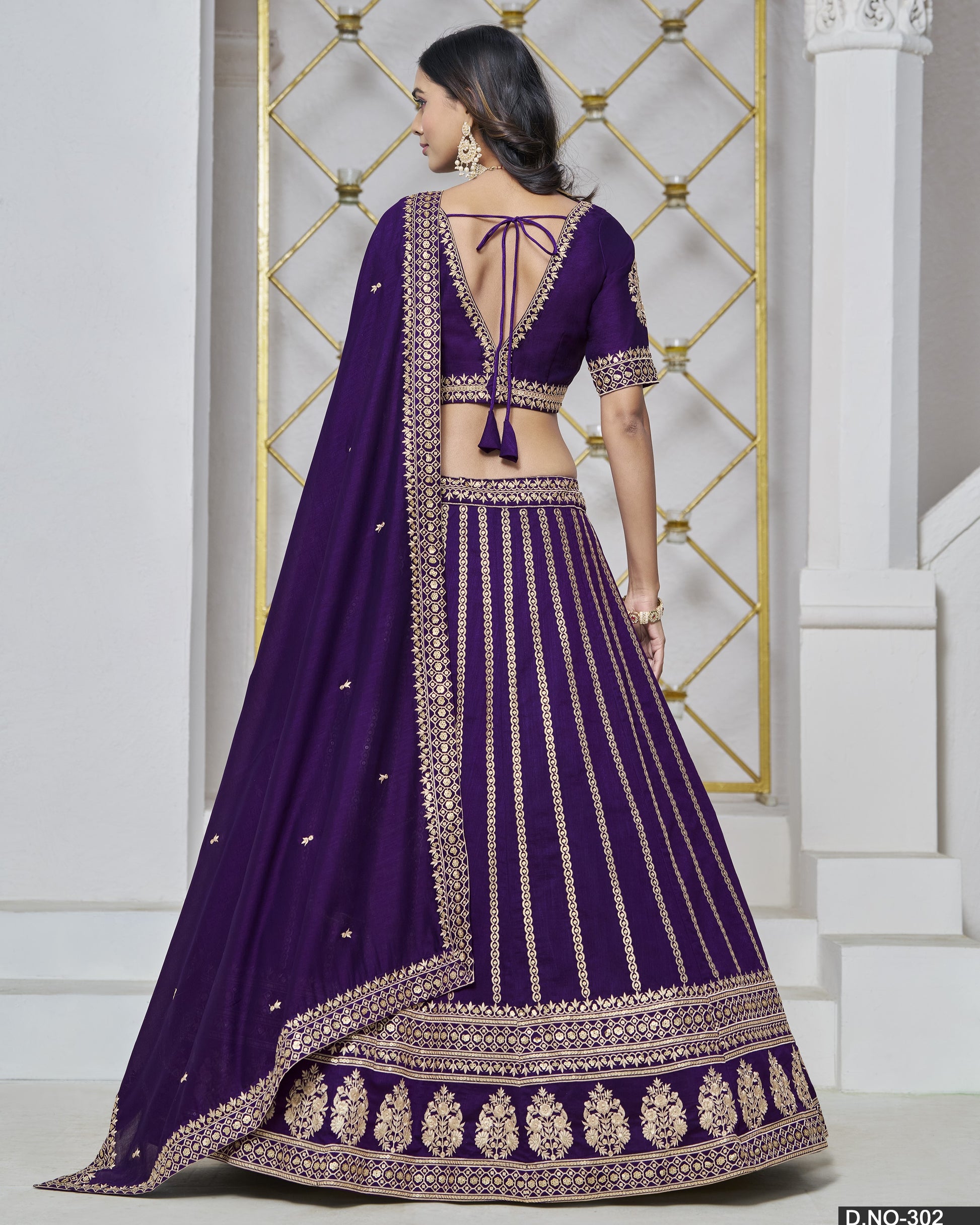 Purple embroidered lehenga with gold details on a white background