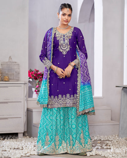 Woman wearing a traditional outfit with purple and green colors in an indoor setting.