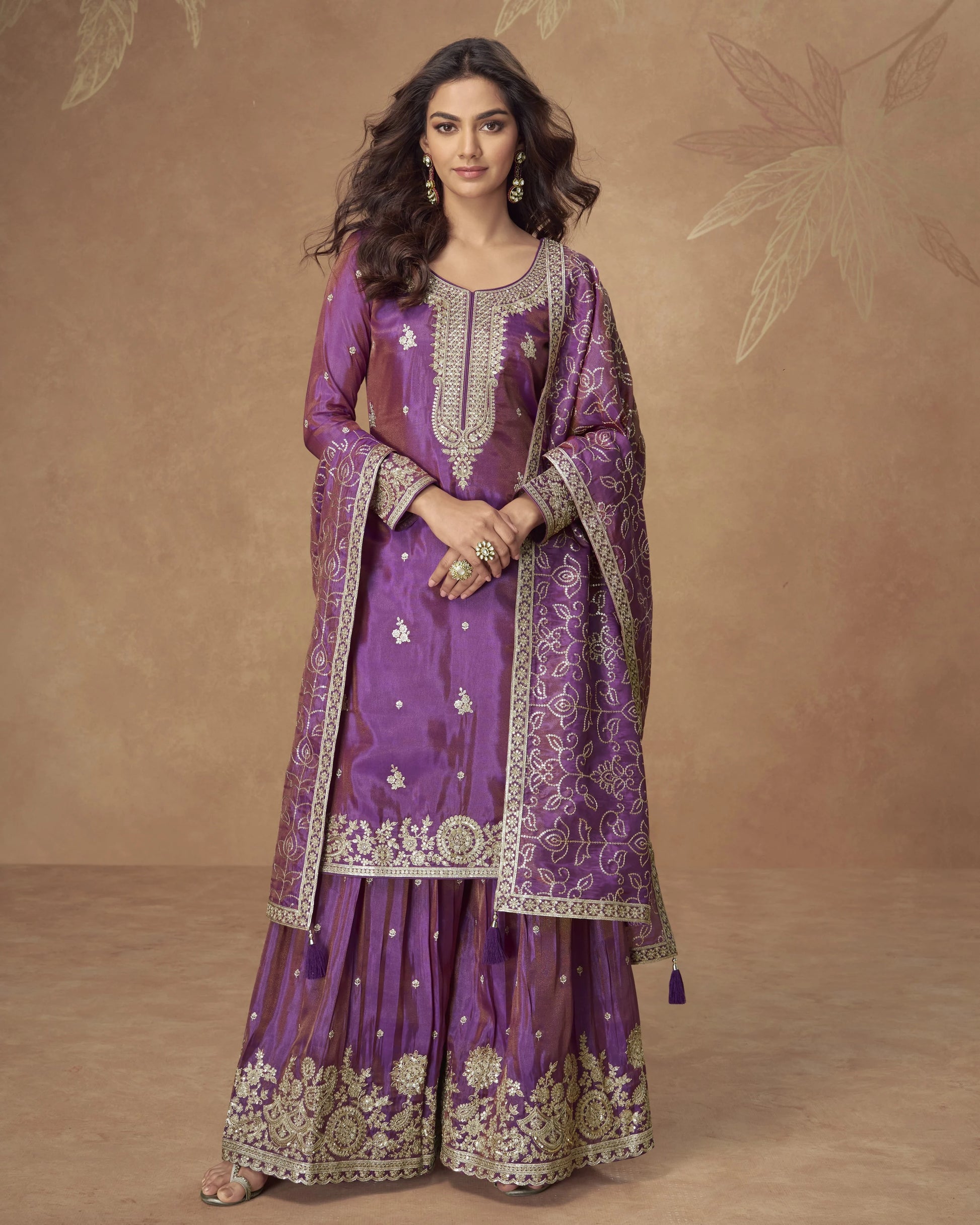 Woman wearing a traditional purple embroidered outfit on a brown background