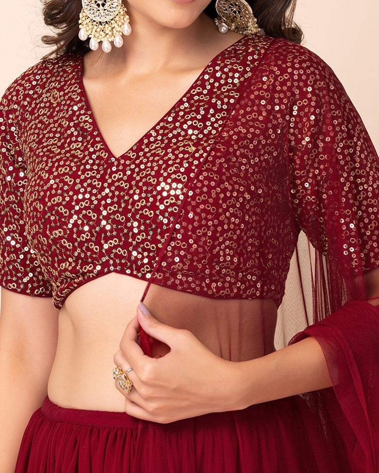 Red sequin blouse worn by a person, with a beige background