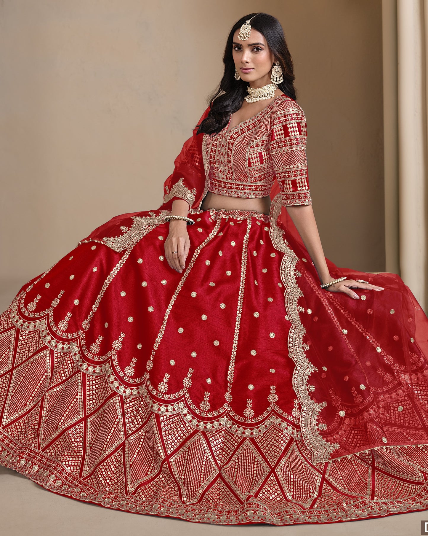 Woman wearing a red embroidered traditional outfit with gold details on a neutral background