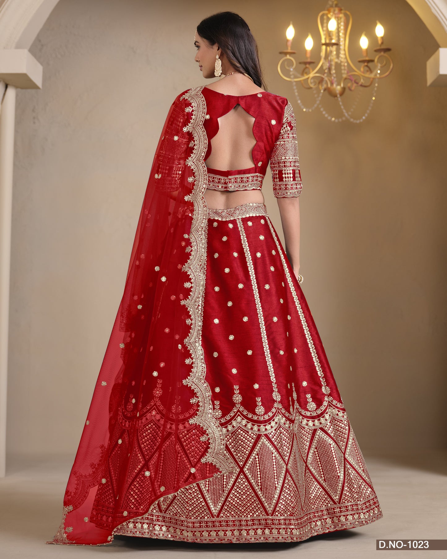 Red embroidered traditional outfit with a chandelier in the background