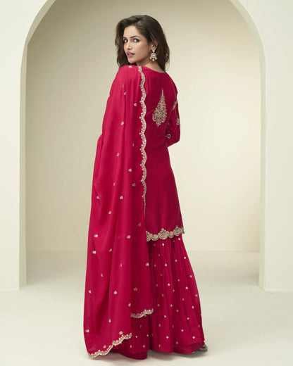 Woman wearing a red embroidered traditional outfit with a white background