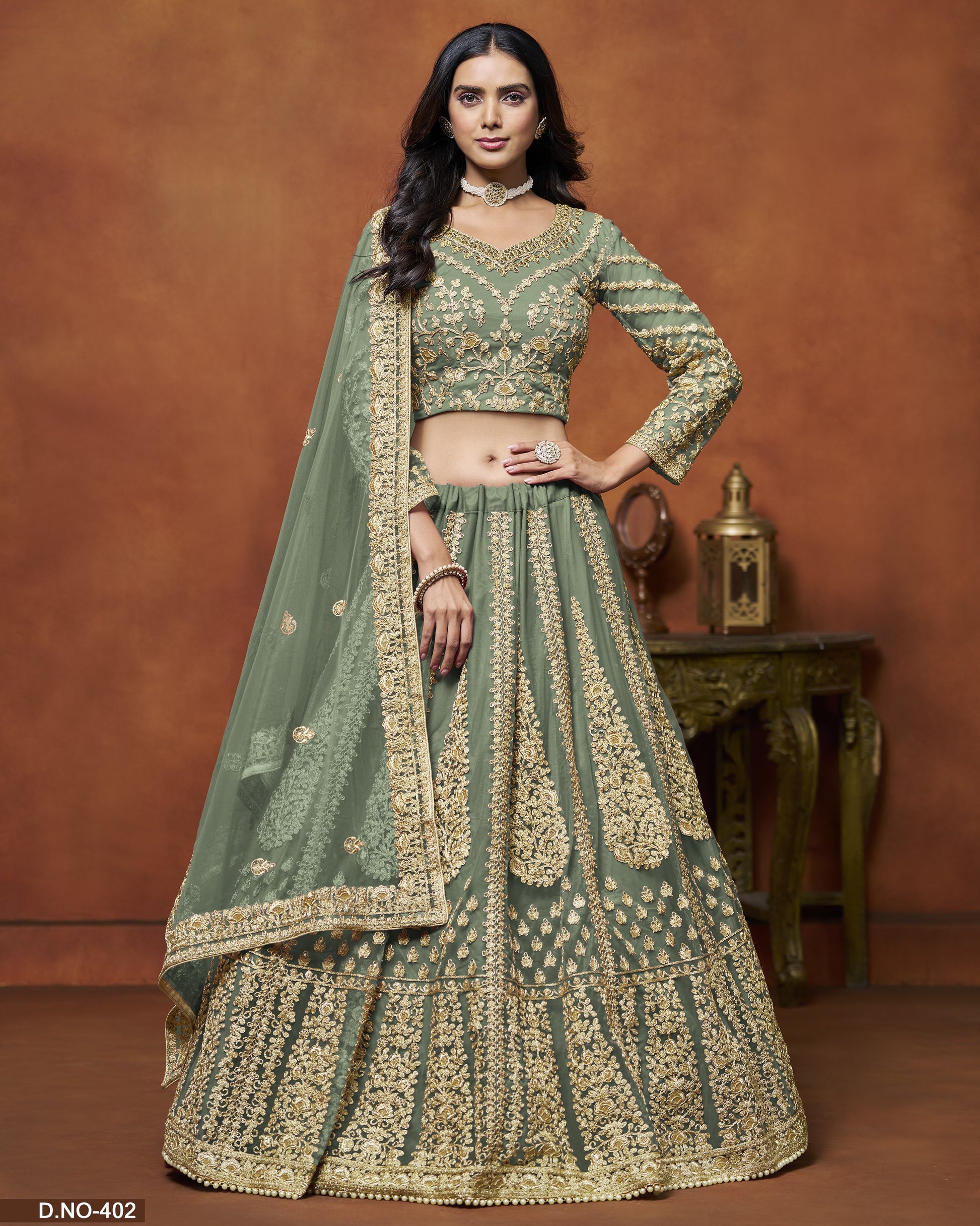 Woman wearing a green and gold traditional outfit with a brown background