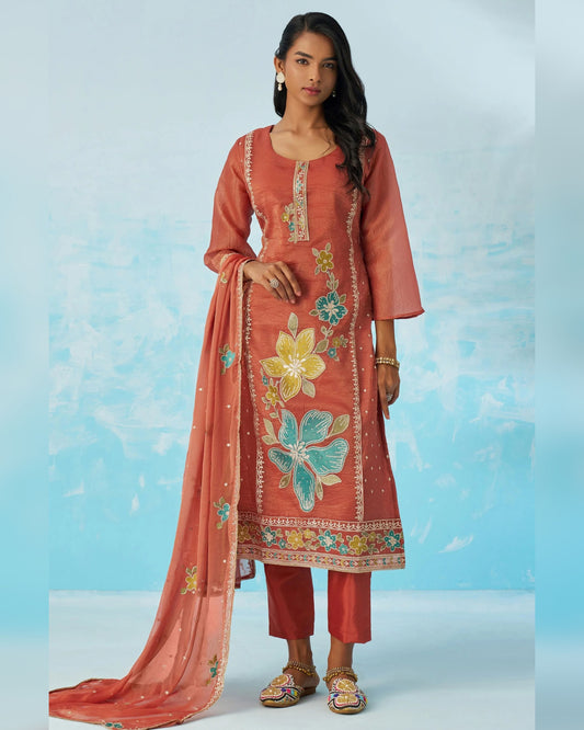 Woman wearing a traditional outfit with floral embroidery on a light blue background