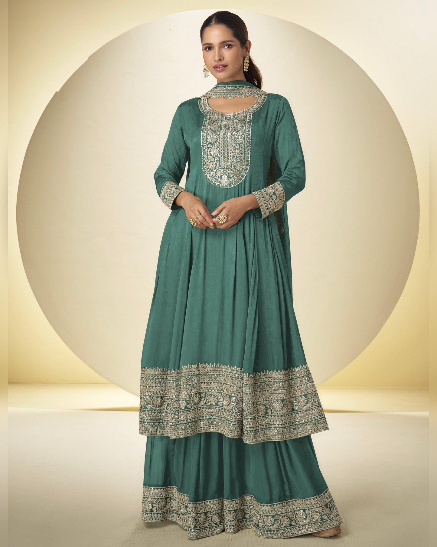 Teal traditional outfit with intricate patterns on a neutral background