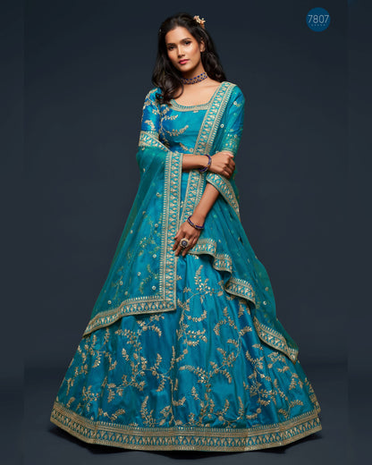 Woman wearing a blue embroidered traditional outfit on a dark background