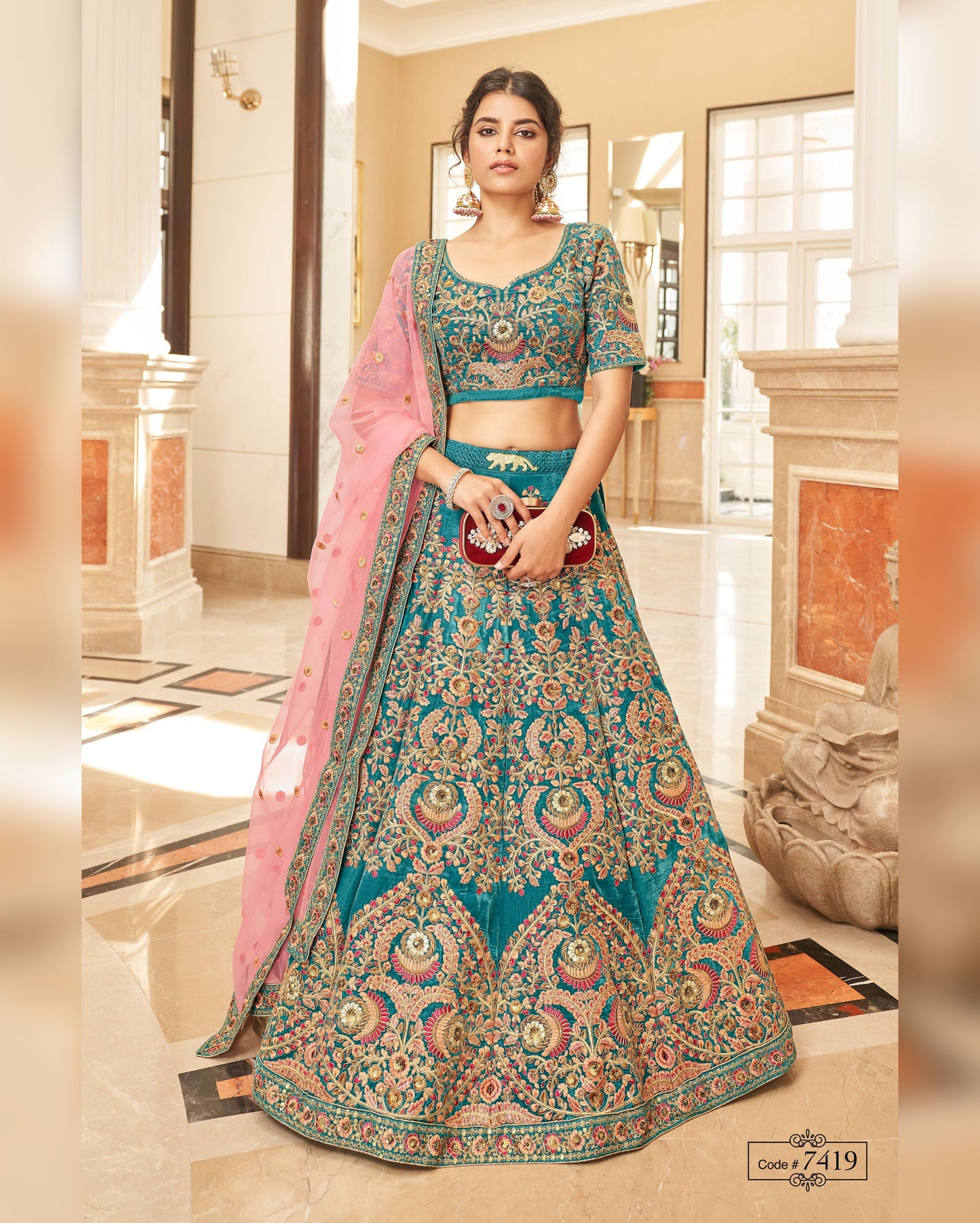 Woman wearing a traditional blue and pink embroidered lehenga in an indoor setting.