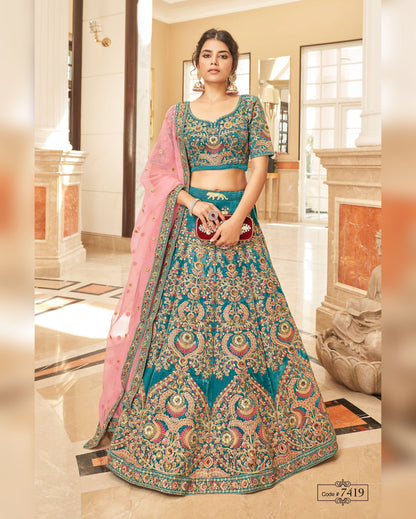 Woman wearing a traditional blue and pink embroidered lehenga in an indoor setting.