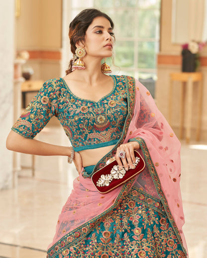 Woman in traditional outfit with pink and blue saree holding a red clutch.