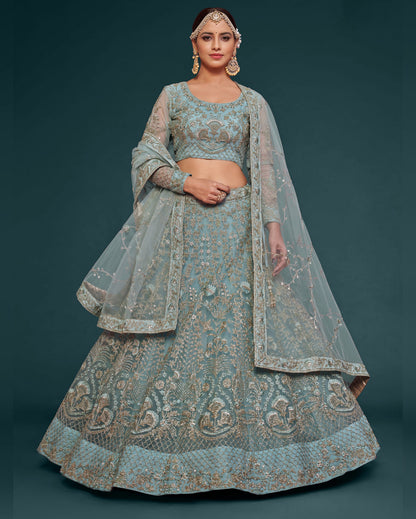 Woman wearing a traditional embroidered lehenga with a matching dupatta on a dark background