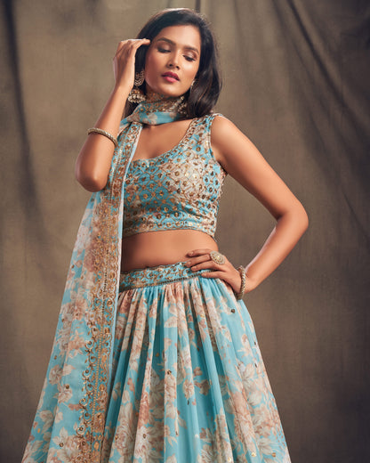 Woman wearing a floral blue and beige traditional outfit against a plain background