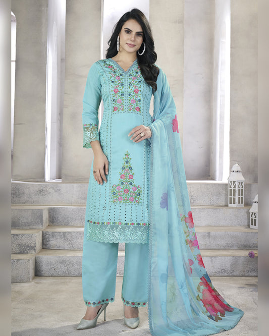 Woman wearing a light blue embroidered outfit with a matching dupatta in a neutral setting.