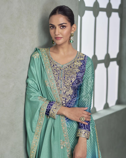 Woman wearing a traditional outfit with intricate patterns against a neutral background