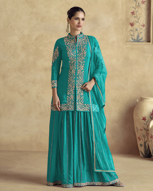 Teal embroidered traditional outfit on a beige background