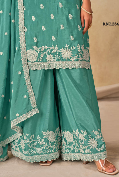 Teal traditional outfit with white floral embroidery on a beige background