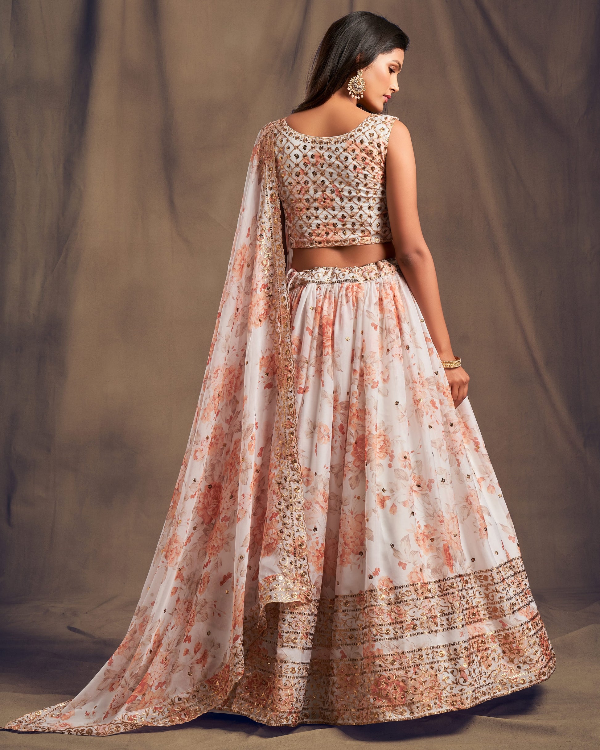 Woman wearing a traditional outfit with floral patterns on a plain background
