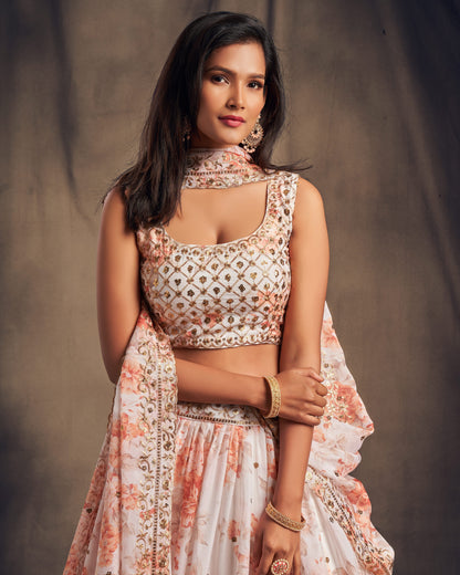 Woman wearing a floral blouse and skirt against a plain background