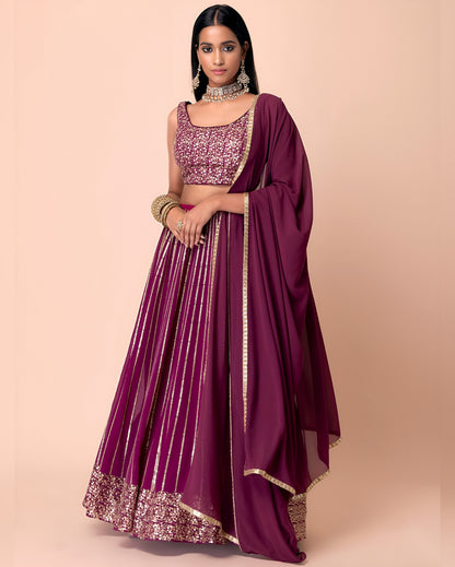 Woman wearing a maroon traditional outfit with gold details on a beige background