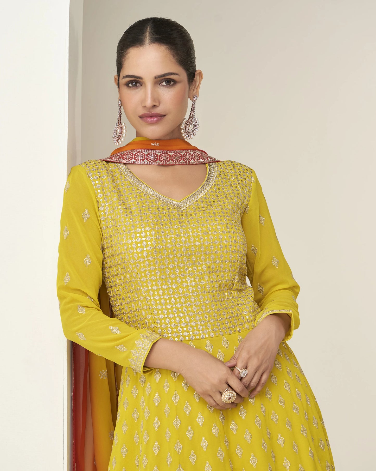 Woman wearing a yellow traditional outfit with a plain background