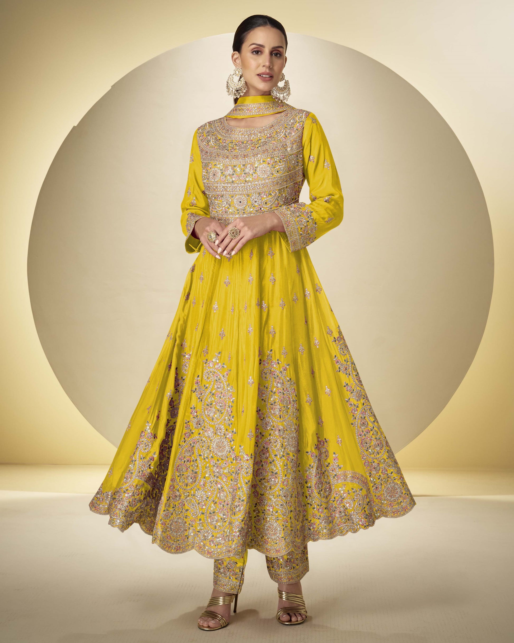 Woman wearing a yellow embroidered traditional outfit on a beige background