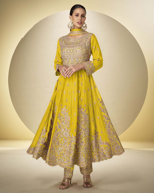 Woman wearing a yellow embroidered traditional outfit on a beige background