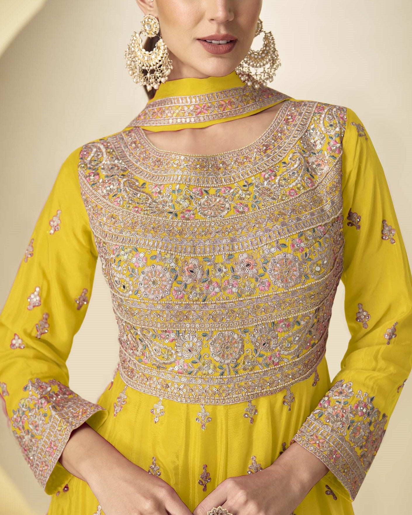 Yellow traditional outfit with intricate embroidery on a neutral background